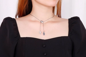 Détail du collier argenté en Y avec curseur cœur et pendentifs garçon et fille