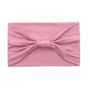 Close-up of pink elastic cotton yoga headband with a decorative twisted knot detail