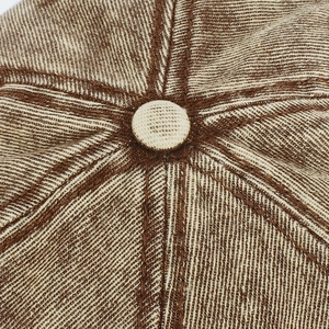 Macro shot of brown and beige twill fabric texture on a six-panel baseball cap top