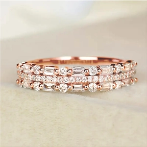Macro shot of rose gold triple-layer ring with baguette and round-cut pavé diamonds