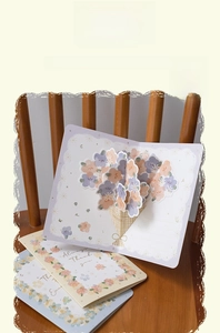 Detailed view of a 3D pop-up floral greeting card with colorful paper bouquet on a chair