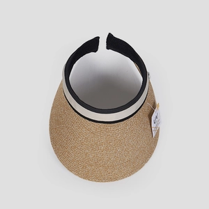 Detalle de visera de paja con etiqueta de protección UV y cinta decorativa bicolor
