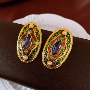 Macro shot of vintage enamel flower earrings with purple crystal and faux pearls