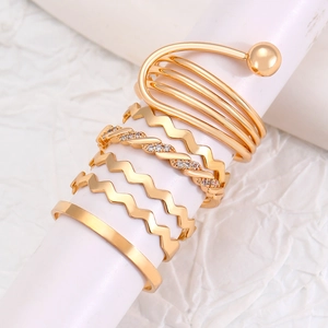 Macro detail of gold stacked ring set with spiral, wavy and crystal designs on a stand