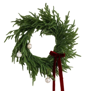 Christmas wreath with green pine branches, red velvet bow, and silver matte ball ornaments