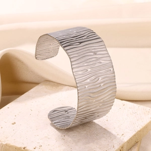 Detail of silver textured wide open cuff bangle with hammered water ripple finish