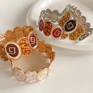 Détail de bracelets vintage en émail avec étoiles, cristaux et maillons en métal