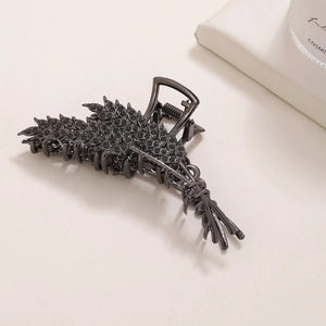 Detail of elegant gunmetal wheat hair claw clip with rhinestones on a white surface