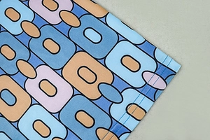 Close-up of retro geometric print fabric with high-quality double-needle hem stitching