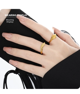 Detailed close-up of a twisted gold leaf ring with a frosted matte finish on model