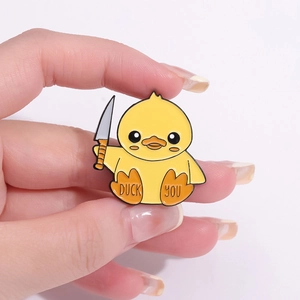 Funny cartoon yellow enamel duck pin holding a knife with Duck You text detail