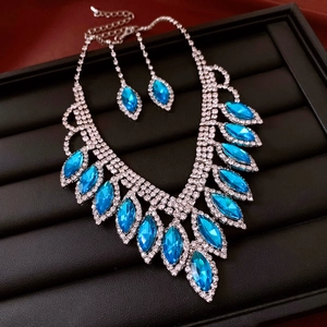 Close-up of diamond waterdrop tassel necklace and earrings set in a black jewelry box