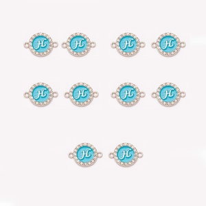 Macro detail of 10 gold letter H charms with blue enamel and crystal rhinestone accents