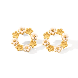 Gros plan détaillé de boucles d'oreilles fleurs dorées avec petites perles et design rond