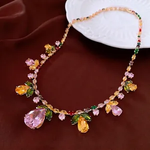 Luxury gold necklace with pink teardrop gemstone and colorful crystals in floral cluster style