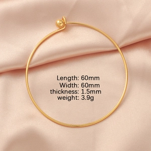 Detail of 60mm gold stainless steel bangle with 1.5mm wire on pink silk background