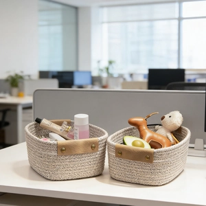 Close-up of woven cotton storage baskets with PU leather handles on a white desk