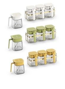 Three-piece kitchen spice jar set in green, yellow, and white with a metal storage rack