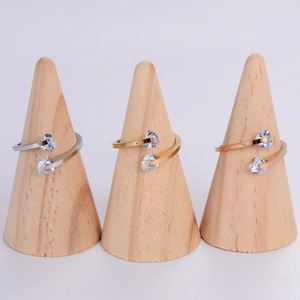 Three minimalist stainless steel open rings with heart zircons on wooden cones