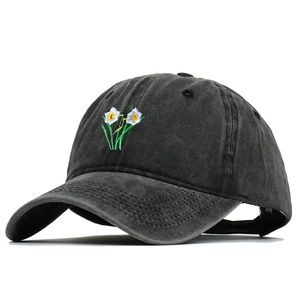 Close-up of narcissus floral embroidery on vintage washed cotton dark gray baseball cap