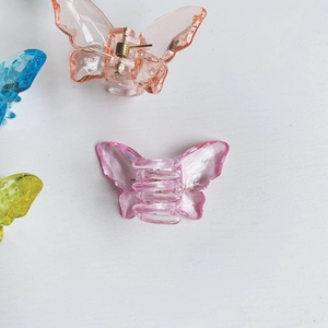 Close-up of colorful acrylic butterfly hair claws with transparent gemstone texture