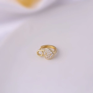 Detail view of a gold-plated heart safety pin earring with sparkling cubic zirconia inlay