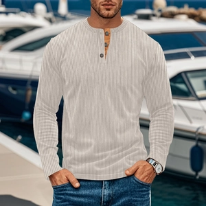 Close-up of beige corduroy Henley shirt buttons and ribbed texture on outdoor background