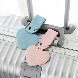 Macro detail of heart-shaped faux leather luggage tags in pink and light blue colors
