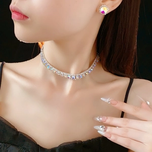 Close-up of sparkling square rhinestone necklace and matching earrings on a model