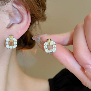 Elegant gold square heart earrings with white enamel and sparkling crystal accents