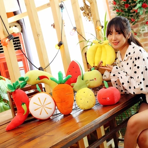 Assorted fruit and vegetable plush toys featuring banana, carrot and apple on a wooden table