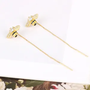 Elegant gold bee tassel threader earrings with sparkling rhinestones on white background