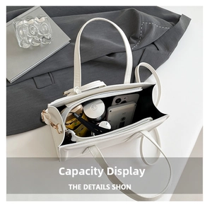 Intérieur spacieux du sac cabas blanc mat montrant téléphone, cosmétiques et parapluie