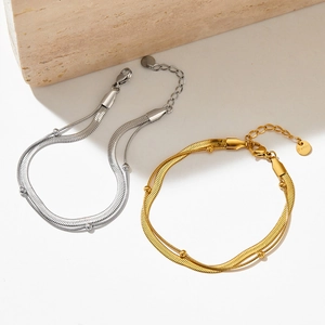 Detail of dual-layer flat snake bone chain bracelets in gold and silver stainless steel