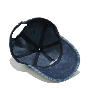 Detailed interior of a blue washed cotton baseball cap with adjustable metal buckle strap