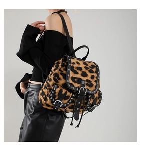 Detail view of leopard print backpack with silver rivets and textured faux leather trim