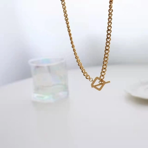 Detailed close-up of a gold metal link chain featuring a stylish OT buckle closure