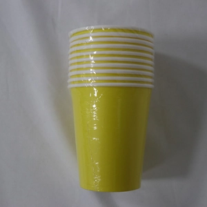 Close-up of stacked yellow disposable paper cups sealed in transparent plastic packaging
