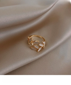 Detail of adjustable gold ring featuring delicate leaf-shaped white mother of pearl inlays
