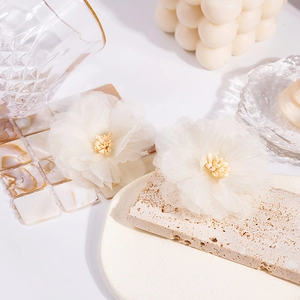 Macro shot of ivory lace floral earring detailing with elegant soft mesh and pearls