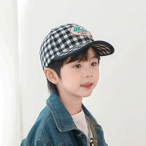 Detailed macro view of houndstooth plaid pattern and oval embroidered patch on kids cap