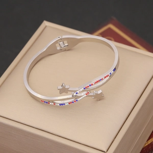 Detailed shot of silver open bangle featuring sparkling red and blue rhinestone star charms