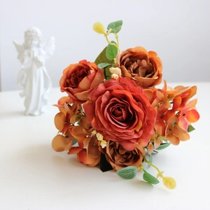 Close-up of artificial silk rose bouquet in burnt orange and caramel colors for decor