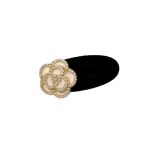 Elegant black camellia hair clip with white pearl edges and glossy petal center on white background