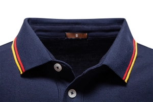 Macro detail of navy polo shirt collar with red and yellow stripes on pique cotton