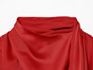 Detail of red satin blouse featuring an elegant high pleated neckline with a silk finish