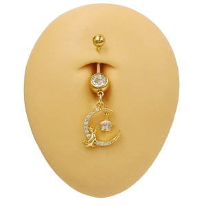 Detailaufnahme von goldenem Bauchnabelpiercing mit Katze auf dem Mond und Sternanhängern