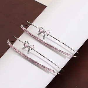 Detail of silver-plated bow bracelet featuring sparkling pink zircon stones and pavé setting