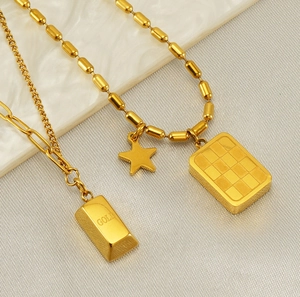Détail du collier en acier titane doré avec pendentifs étoile et damier