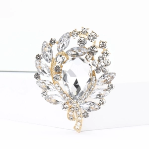 Detailed view of luxury gold leaf brooch featuring brilliant rhinestones and crystal accents